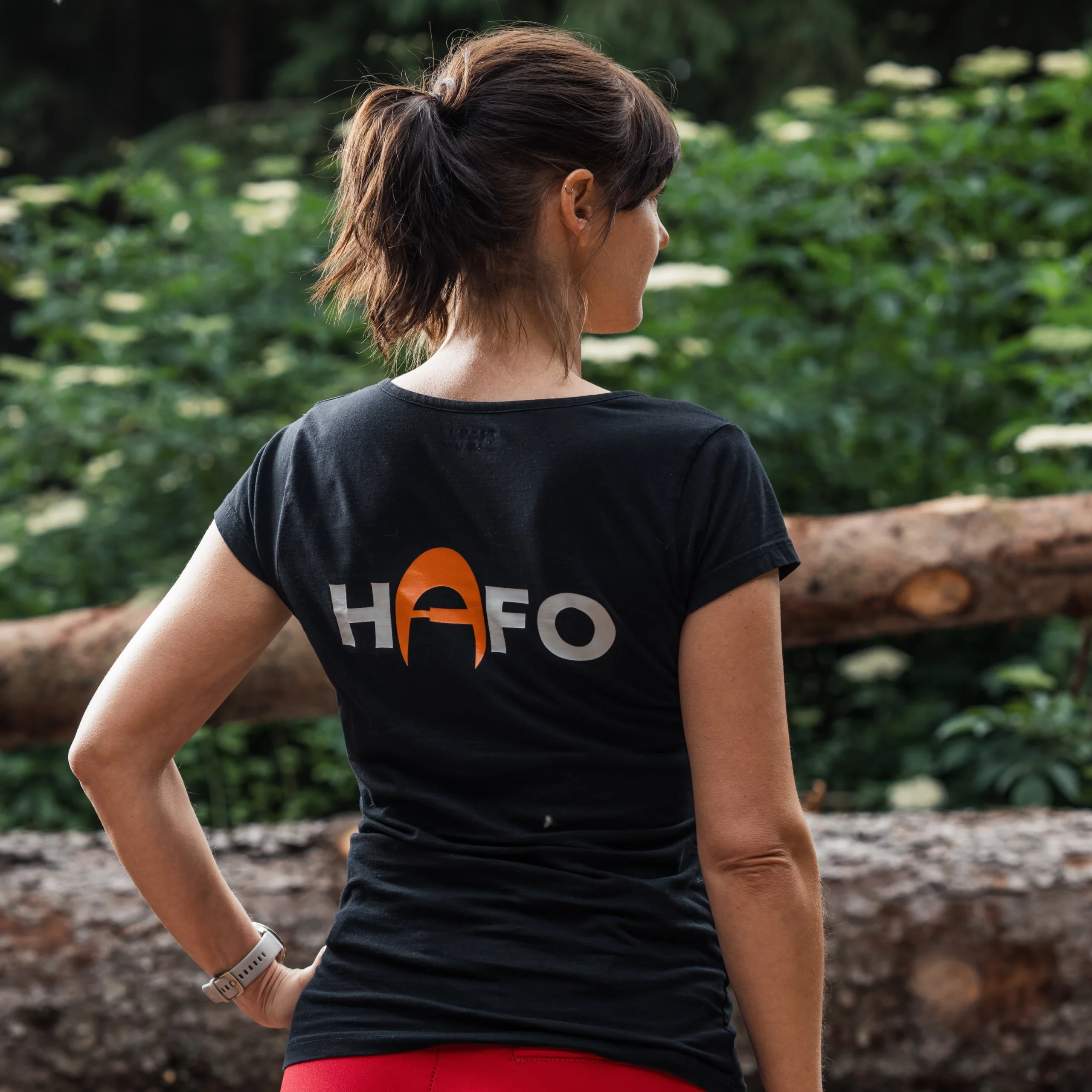 Eine Frau steht mit dem Rücken zur Kamera und trägt ein schwarzes HAFO-T-Shirt. Auf dem Rücken ist der Schriftzug HAFO deutlich zu sehen.