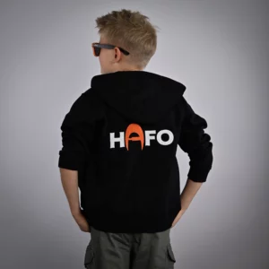 Ein Kind steht mit dem Rücken zur Kamera und trägt den HAFO Hoodie Full Zip Kids. Der Kopf ist seitlich gedreht, auf dem Rücken des Hoodies steht HAFO.